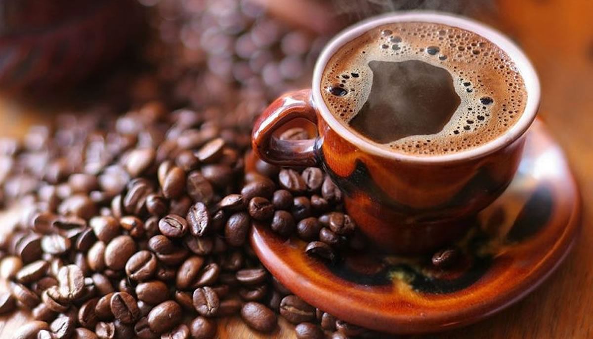 Taza de café rodeada de granos tostados